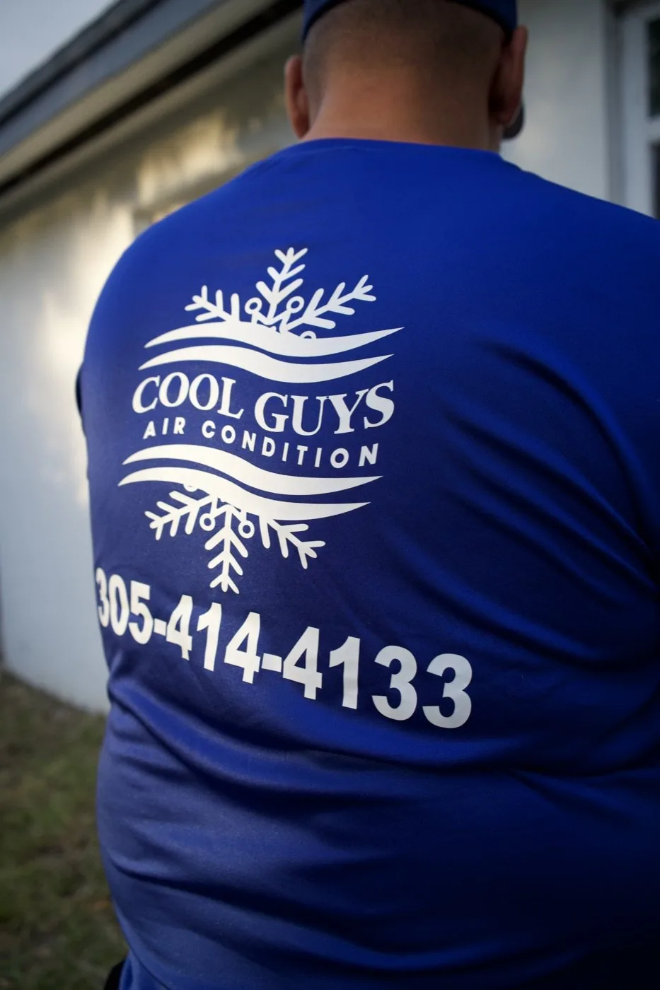 Close-up of a client crew's branded shirt with company phone number, shot in-house by Optic Vault Marketing